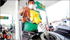  ?? HONG MENEA ?? A fuel attendant fills up a customer’s tank at a TELA filling station in northern Phnom Penh’s Russey Keo district on March 31.