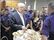  ?? ALEX BRANDON / AP ?? President Donald Trump prepares to hand out sandwiches to members of the U.S. Coast Guard at the Lake Worth Inlet Station in Riviera Beach, Fla., near his Mar a Lago resort, on Thursday.