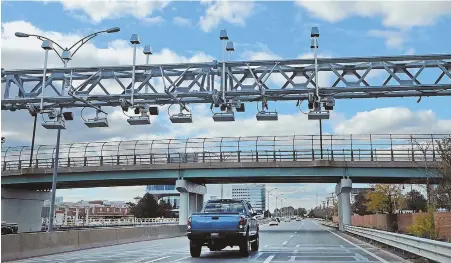  ?? STAFF PHOTO BY NANCY LANE ?? E-Z TAX: Cars pass through the electronic toll system in place on the Massachuse­tts Turnpike in Allston yesterday.