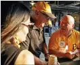  ?? GENE J. PUSKAR — THE ASSOCIATED PRESS ?? Tom Congdon, center, a vendor at Pittsburgh sports venues for 38 years, mans his beer and water cart in the concourse at PNC Park for a baseball game between the Pittsburgh Pirates and the Atlanta Braves in Pittsburgh Monday.