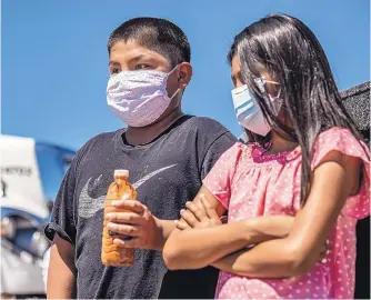  ?? ANTHONY JACKSON/JOURNAL ?? Omar Apachito holds a bottle of water from a To’hajiilee home as he and Paris Apachito appear at a news conference to show the water quality in the community.