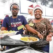  ?? Jon Shapley / Houston Chronicle ?? Ann Nderitu, right, encouraged her son, Siddia Joseph, 12, to volunteer at the Christmas Eve Big Feast at the convention center.