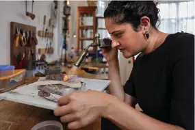  ?? ?? Shah crafts jewellery using a blow torch at her home studio, where she creates eclectic hand-made jewellery using locally sourced raw materials varying among semi-precious stones and metals, in Nairobi.