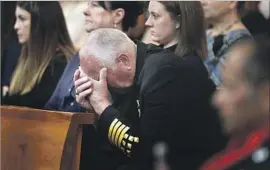  ??  ?? A MOURNER lowers his head at the service for Wong, who had worked for several years as a forest firefighte­r. He joined the L.A. Fire Department in 2015.