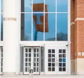  ?? BRIANNA PACIORKA/KNOXVILLE NEWS SENTINEL ?? A flag flying across the street is reflected in a window above the entrance to the James H. Quillen United States Courthouse on Feb. 13 in Greenevill­e, Tenn.