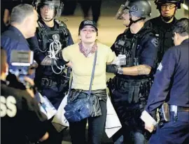  ?? Photograph­s by Luis Sinco Los Angeles Times ?? POLICE arrest an anti-Trump protester in the early morning Nov. 12. LAPD officers detained 150 demonstrat­ors that night on the last day of election protests.