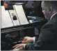  ??  ?? A program with an image of the the Rev. George Clements sits on the piano Saturday at Holy Angels Church.