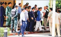  ?? PHA LINA ?? Refugees from an Australian-run detention centre in Nauru and their handlers leave Phnom Penh Internatio­nal Airport in 2015 after travelling to the Kingdom for resettleme­nt.