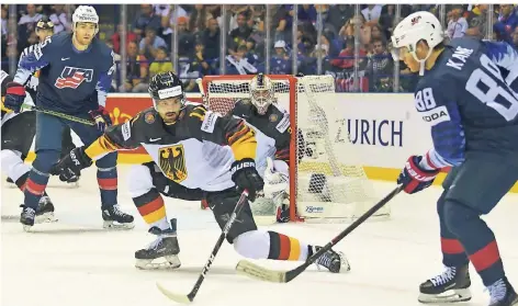  ?? FOTO: BIRGIT HÄFNER ?? Marco Nowak (weißes Trikot, vorn) versucht, einen Schuss von NHL-Star Patrick Kane (re.) abzublocke­n. Torhüter Mathias Niederberg­er ist bereit.