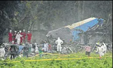  ?? AP ?? Rescue teams search through the wreckage at the crash site.