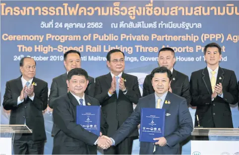  ?? CHANAT KATANYU ?? Acting head of the State Railway of Thailand Worawut Mala, left, and Charoen Pokphand Group CEO Suphachai Chearavano­nt shake hands with signed contracts for the high-speed train linking three airports at Government House yesterday. Prime Minister Prayut Chan-o-cha witnessed the signing.
