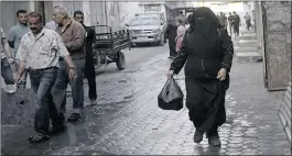  ??  ?? Samia Hassan returns home with wheat porridge distribute­d by Walid al-Hattab,