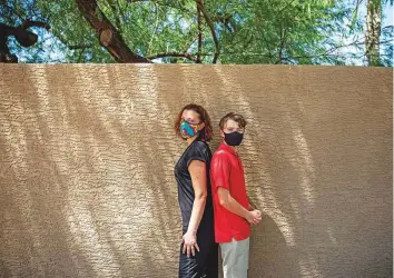  ?? New York Times ?? Sandy Kirby and her son Nathan, 12, one of only a few students in his class wearing a mask in Arizona. New Covid cases are forcing thousands of children and teachers into quarantine, igniting a political uproar for Governor Doug Ducey who banned mask mandates in Arizona.