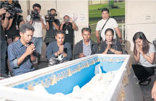  ??  ?? GONE TOO SOON: Family members pay respect to Rung. She was laid to rest at Wat Mongkolnim­itr in Samut Prakan’s Bang Sao Thong district.