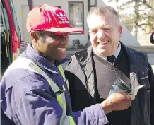  ?? FOR THE CALGARY HERALD ?? Fred Bediako, left, who forgot his wallet containing $ 1,500 on a Calgary Transit bus Monday morning, is all smiles alongside his new “hero,” bus driver Mustaf Gashi, who found it.