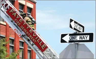  ?? NWA Democrat-Gazette/DAVID GOTTSCHALK ?? Members of the Fayettevil­le Fire Department respond July 7 to the report of smoke in a building in downtown Fayettevil­le. The smoke was the result of working being done in the building.