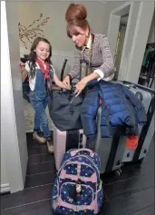  ?? Dan Watson/The Signal ?? Violet’s mother, Jackie McGraw, looks over luggage after returning from filming in Atlanta.