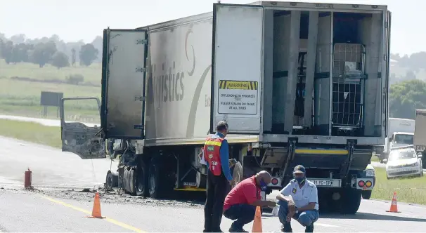  ?? Picture:
Neil McCartney ?? CRIME SCENE. Police look for clues to help them clamp down on truck attacks. Another two trucks were set alight during attacks on the N12 road near Daveyton in Ekurhuleni early yesterday.