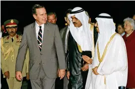  ?? J. SCOTT APPLEWHITE / AP ?? President George H.W. Bush is greeted by King Fahd as he arrives in Saudi Arabia in 1990. Bush’s friendship with King Fahd is credited with making Saudi Arabia a strong ally of the United States, especially through the Persian Gulf War.
