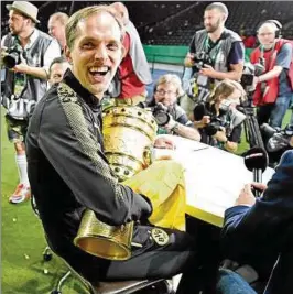  ??  ?? Mit Trophäe im Fokus der Kameras: Dortmunds Trainer Thomas Tuchel gewann in Berlin seinen ersten großen Titel. Foto: Imago