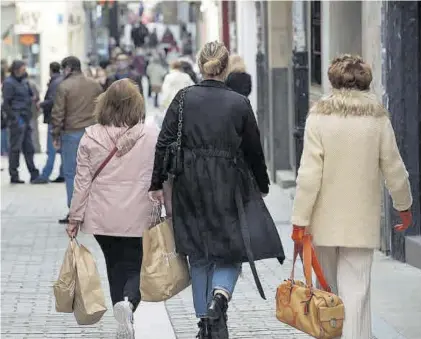  ??  ?? Dos mujeres con bolsas de compra, por la calle del Sol.