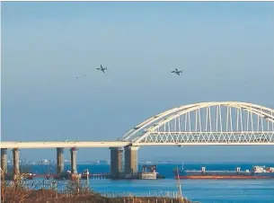  ?? KERCH INFO/AFP/GETTY IMAGES ?? Russian jets fly over the Crimean Bridge above the Kerch Strait on Sunday as a Russian ship blocks the strait, after Russia fired on and seized three Ukrainian ships.