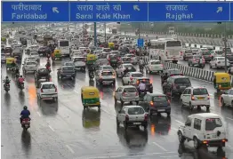  ?? — PTI ?? The traffic moves at snail's pace during office hours near Akshardham temple, as it rains in New Delhi on Wednesday.