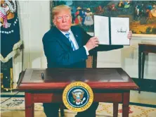  ?? AP Photo ?? DELIVERING: President Trump signs a presidenti­al memorandum on the Iran nuclear deal earlier this week.