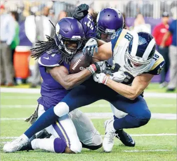  ?? Bruce Kluckhohn Associated Press ?? RAMS RECEIVER Cooper Kupp has the ball stripped by safety Anthony Harris, left, at the Minnesota Vikings’ one-yard line late in the second quarter as linebacker Eric Kendricks helps out.