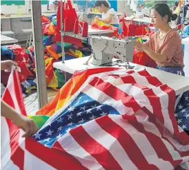  ?? /Reuters ?? A worker makes US national flags at Jiahao flag factory in Fuyang, Anhui province, China. The US is locked in a bitter trade war with China as well as trade disputes with other trade partners.