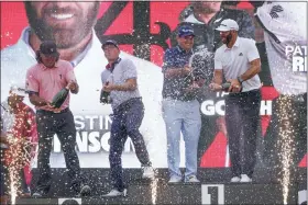  ?? SETH WENIG — THE ASSOCIATED PRESS ?? The “4Aces” team celebrates with champagne after winning the team competitio­n during a ceremony after the final round of the Bedminster Invitation­al LIV Golf tournament in Bedminster, N.J., Sunday, July 31, 2022. From left to right, Pat Perez, Talor Gooch, Patrick Reed and Dustin Johnson.