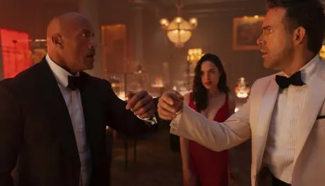  ?? Frank Masi, Netflix ?? “Red Notice,” starring Dwayne Johnson (left), Gal Gadot and Ryan Reynolds, was viewed a total of 148 million hours in its first weekend, according to Netflix.