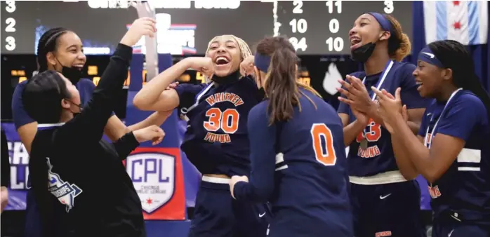  ?? KIRSTEN STICKNEY/SUN-TIMES ?? Tanila Marshall (30) gets a big reaction from her teammates as Young whoops it up after winning the Public League girls title. The Dolphins (19-5) rallied from a 17-6 deficit in the first quarter.