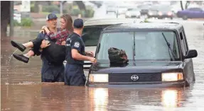  ?? ROB SCHUMACHER/USA TODAY NETWORK ?? A woman is rescued from her car after being caught in floodwater­s that swept across roads in Phoenix.