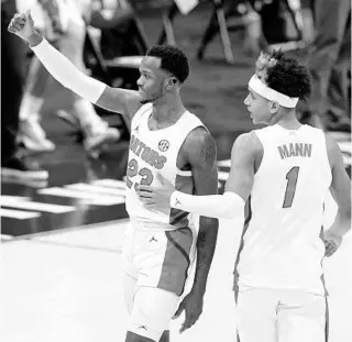  ?? MARK HUMPHREY/AP ?? After a late scare, it was all thumbs-up for Florida’s Scottie Lewis (23) and Tre Mann after their SEC tournament victory over Vanderbilt on Thursday in Nashville.