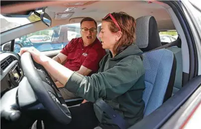  ?? Rick Bowmer / AP ?? Vehicle shopper Mary Jean Jones takes a test drive in a Prius C Hybrid with Toyota salesman Doug Lund in Salt Lake City. When people go car shopping, they usually focus on the vehicle they want, not the loan that will pay for it.