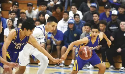  ?? PHOTO AARON BODUS ?? Southwest’s Alberto Zavala (left) and Leo Castillo (right) scramble after a ball they’ve poked away from Central’s Jordan Reed (center), during the Eagles’ 53-51 win over the Spartans on Tuesday in El Centro.