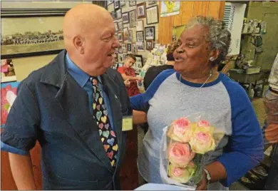  ?? PETE BANNAN – DIGITAL FIRST MEDIA ?? In this file photo Coatesvill­e Flower Shop owner Greg DePedro gives Cora Wilson, of Coatesvill­e roses as part of ‘Lisa’s Roses.’ Each year the shop gave away a dozen free roses to each customer to remember their daughter, Lisa, who died of cancer. The recipient may keep one but give the other eleven away.