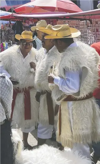  ?? SUZANNE MORPHET ?? Mayan men in traditiona­l dress socialize at the Sunday market in San Juan Chamula.