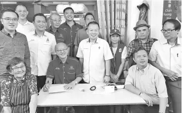  ??  ?? Standing, Phoong (left),Tan (third left), Chan (fourth right) and others at the mobile service centre at Gaya Street.