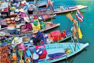  ??  ?? Waterborne adventure: A floating market at Can Tho and (top) Angkor Wat