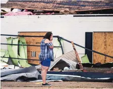  ?? CHRIS GRANGER/ASSOCIATED PRESS ?? A business owner surveys the damage from Hurricane Laura on Friday in Lake Charles, Louisiana. Fallen power lines and trees made it difficult to drive in the area.