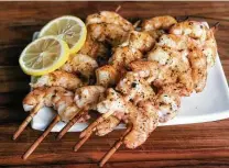  ?? Marvin Pfeiffer / Staff photograph­er ?? Brined, seasoned and sauced shrimp are skewered and grilled.