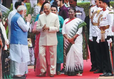  ?? ALTAF HUSSAIN / REUTERS ?? Prime Minister Narendra Modi of India (left) clasps his hands together while greeting outgoing president Ram Nath Kovind (center) and new President Droupadi Murmu after they inspected an honor guard following Murmu’s swearing-in ceremony, in New Delhi on Monday.