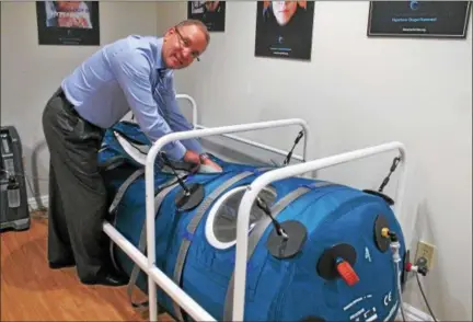  ?? LAUREN HALLIGAN — LHALLIGAN@DIGITALFIR­STMEDIA.COM ?? Dr. Harry Lindman prepares a Hyperbaric Oxygen Treatment chamber at the new Center for HBOT in Saratoga Springs.