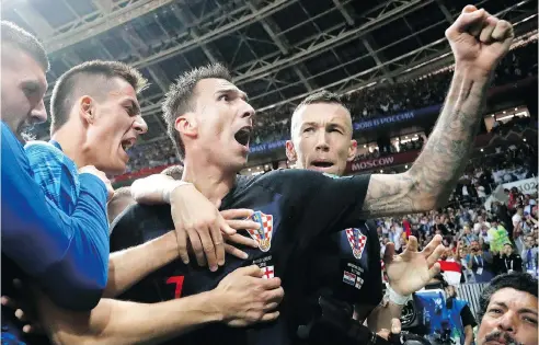  ?? FRANK AUGSTEIN / THE ASSOCIATED PRESS ?? Croatia’s Mario Mandzukic, centre, celebrates after scoring his side’s winning goal in extra time during the semifinal match between Croatia and England at the 2018 soccer World Cup in Luzhniki Stadium in Moscow, sending Croatia to its first Cup final and ending England’s impressive run.