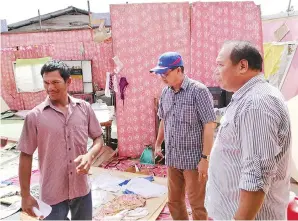  ??  ?? ABDUL Rahman (tengah) dan James meninjau rumah rosak akibat bencana angin ribut di Kg Air.