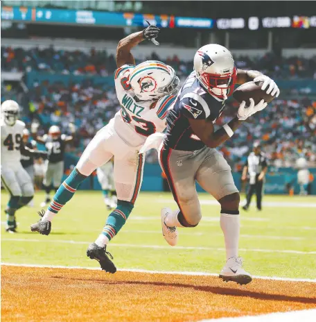  ?? MICHAEL REAVES/GETTY IMAGES ?? Pats receiver Antonio Brown scores a touchdown Sunday in New England’s 43-0 romp over the host Miami Dolphins.