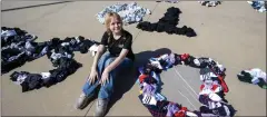  ?? ?? Sidney Vansleve, 12, sits among the 200,000 pairs of sock she collected. With help of volunteers, she constructe­d the world's longest sentence written with socks at BMO Stadium in Los Angeles, Monday. The socks collected by Vansleve will be dispersed to centers operated by Hope the Mission for the homeless.