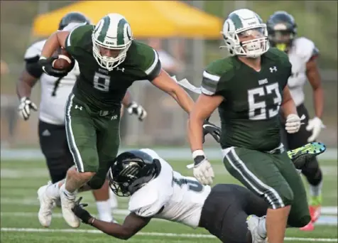  ?? Emily Matthews/Post-Gazette ?? Pine-Richland’s Jeremiah Hasley tries to elude Harrisburg defender Anthony Day Saturday. Harrisburg defeated Pine-Richland, 26-21, in the “Western Pa. vs. Everyone” showcase.